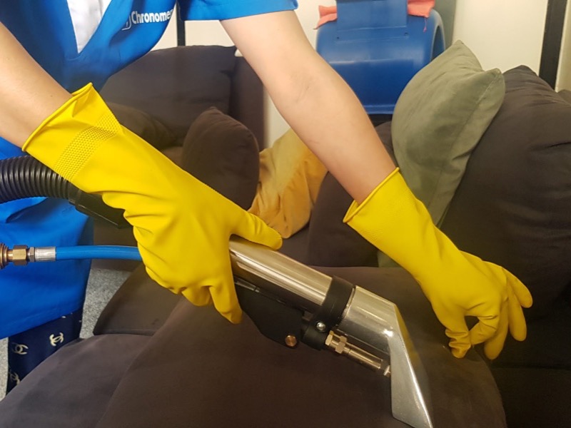 Intervenante Chronomenage nettoyant un canapé en tissu à l'injection-extraction